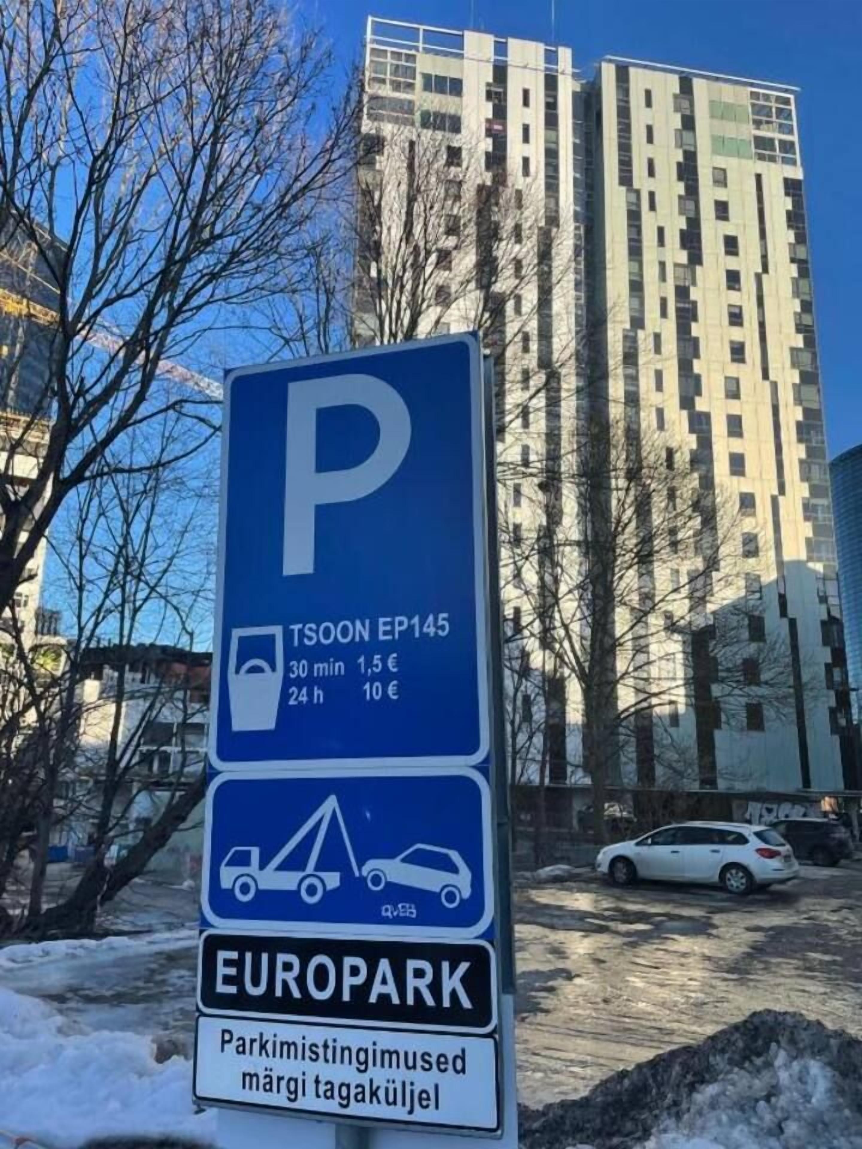 A parking sign with a blue background and white lettering, indicating a parking area named 'TSOON EP145' with rates for 30 minutes and 24 hours.