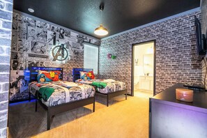 Ein Schlafzimmer mit zwei Betten, einer Ziegelwand und Dekorationen zum Thema Comics.
