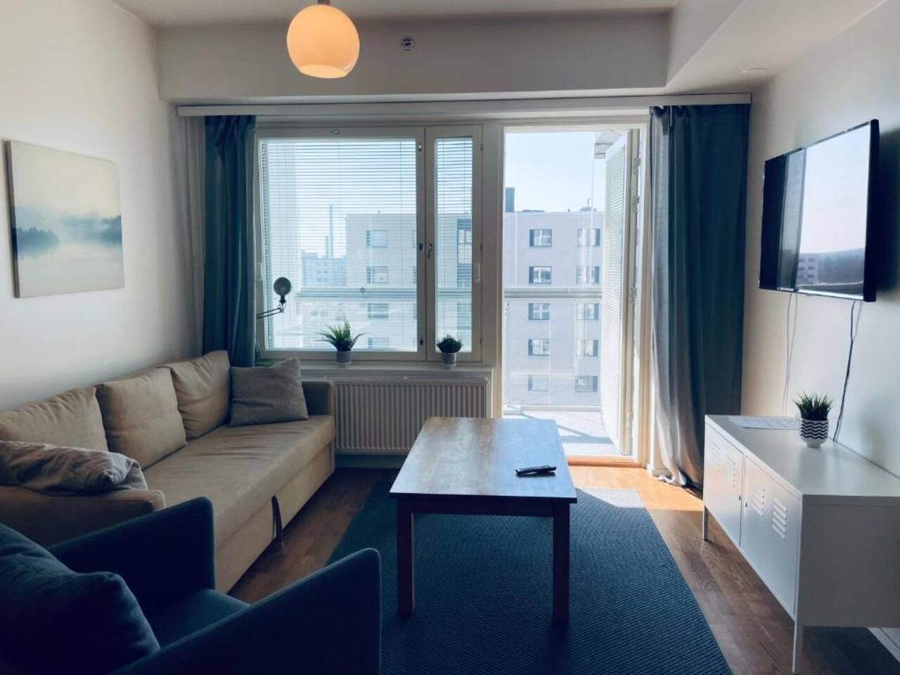 Una sala de estar moderna con un sofá, una mesa de centro y un televisor montado en la pared.