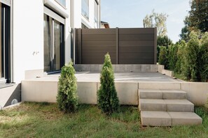 A modern building with a flat roof, a concrete staircase, and a metal fence. - Fischer's Apartment 1: New construction, first-time occupancy, modern and stylish, quiet, parking space, terrace (Starnberg)