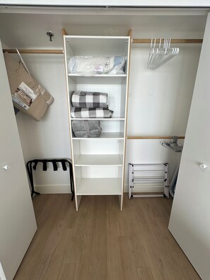 A walk-in closet with shelves, a hanging rack, and a radiator. - Sleeps 6 • Oceanfront • Panoramic Views • Private Balcony • Indoor & Outdoor Pools • Hot Tub • Elevator • Direct Beach Access • Washer & Dryer (Carolina Beach)