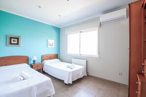 A hotel room with two beds, a window, a radiator, and a wooden wardrobe. - Villa Mahon - Six Bedroom Villa, Sleeps 12 (Javea)