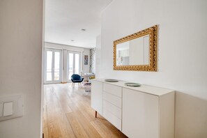 A modern interior with a white cabinet, a large ornate mirror, and a blue chair. - Hostmate - Milano - C. Buenos Aires - City Center (Milan)