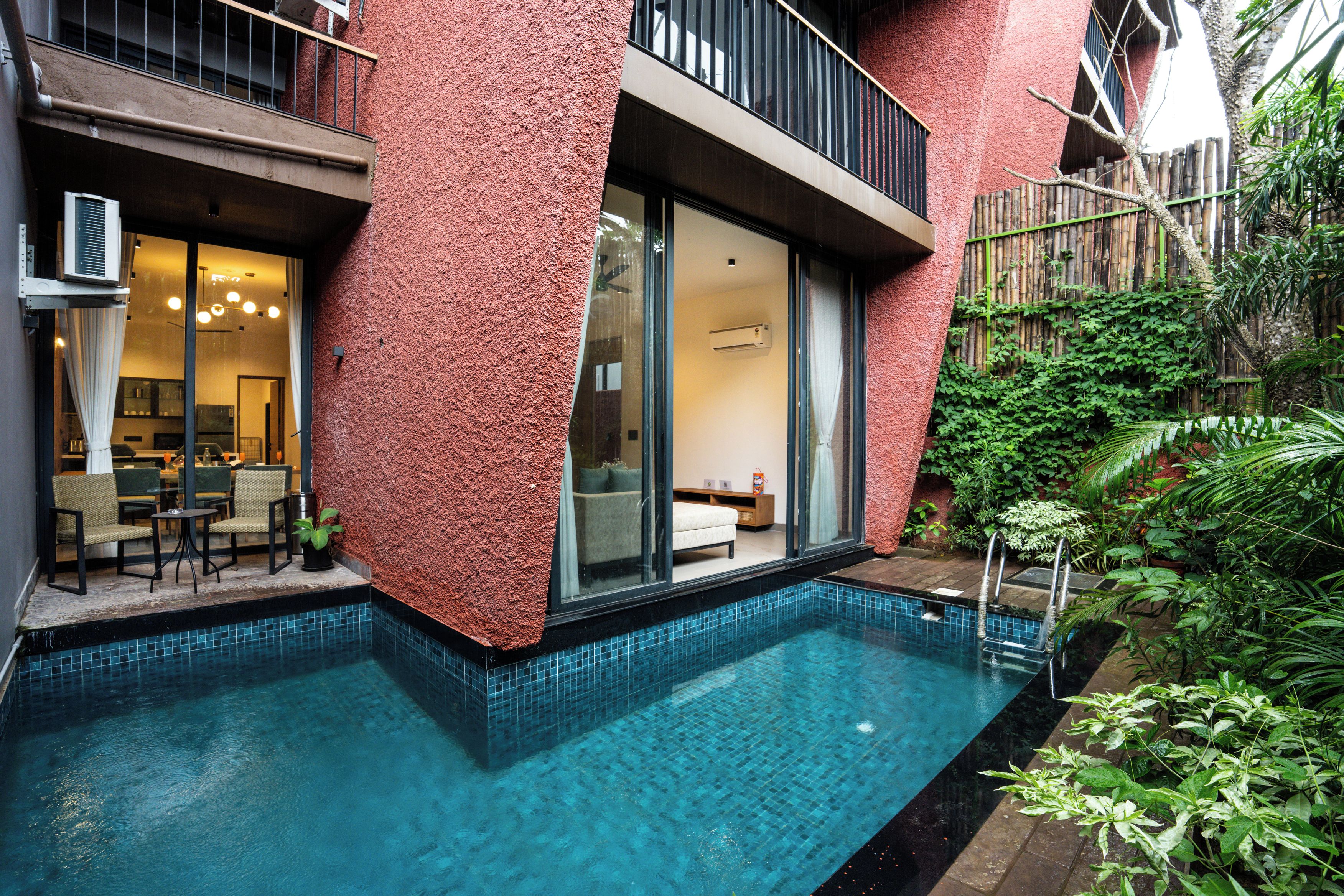 A residential property with a swimming pool, a balcony, and a view of a lush garden.