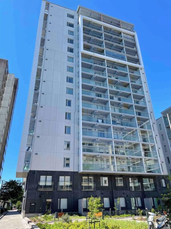 A high-rise building with multiple balconies, large windows, and a modern architectural design.