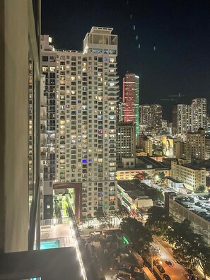 A high-rise building with multiple floors and balconies, surrounded by other buildings and a busy street with cars. - Alea Miami (Miami)