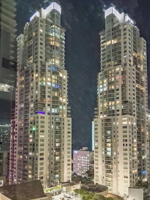 Two high-rise buildings with multiple floors and balconies, illuminated by artificial lighting. - Alea Miami (Miami)
