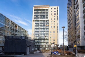 Un edificio residencial de varios pisos con un diseño arquitectónico moderno, que cuenta con balcones y grandes ventanales.