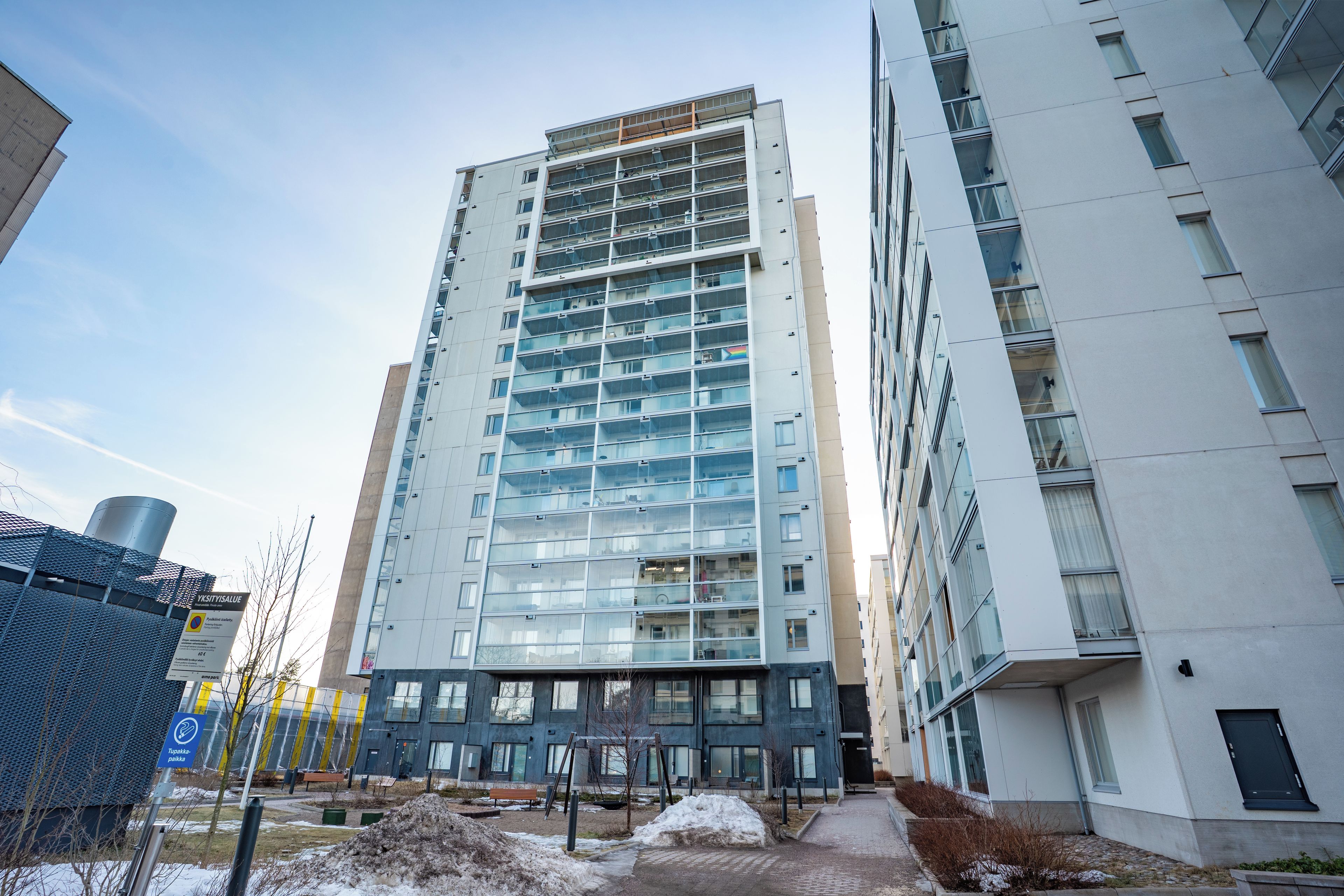 A multi-story residential building with a modern architectural design, featuring large windows and balconies.