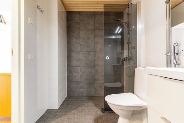 Un baño con ducha, inodoro y lavamanos.
