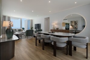 Et moderne interiør med spiseplads, sofaarrangement og et stort spejl.