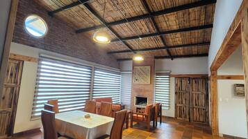 A spacious dining area with a high ceiling, wooden beams, and a checkered floor.