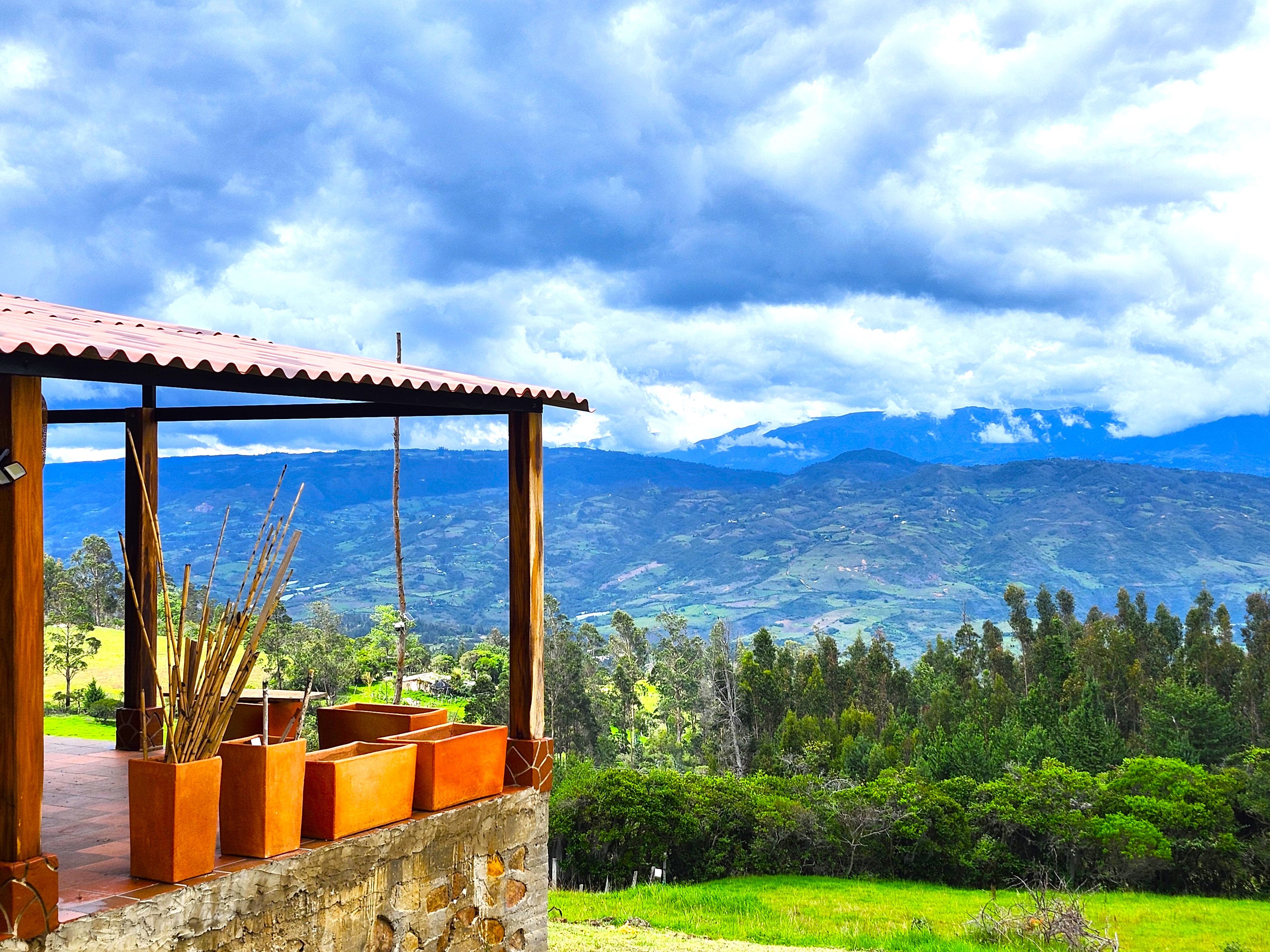 A wooden structure with a tiled roof overlooking a mountainous landscape.