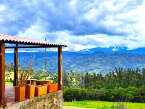 A wooden structure with a tiled roof overlooking a mountainous landscape.