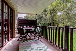A covered outdoor seating area with a table, chairs, and a checkered mat. - Host and Stay | Lodge 8 (Dailly)