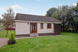 A single-story building with a tiled roof, a front door, and a small porch. - Host and Stay | Lodge 8 (Dailly)
