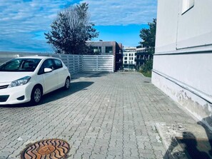 Un camino pavimentado que conduce a un edificio con una pared exterior blanca.