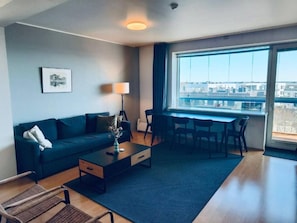 Ein modernes Wohnzimmer mit Sofa, Couchtisch und Essbereich.