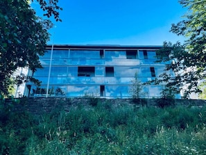 Un edificio de varios pisos con un diseño arquitectónico moderno, que destaca por sus amplios ventanales y techo plano.