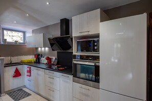 A modern kitchen with a built-in microwave, oven, and a Bosch refrigerator.