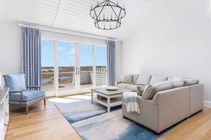 Un salon spacieux avec un canapé, un fauteuil et une table basse.