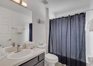 Ein Badezimmer mit Waschbecken, Spiegel und Toilette.