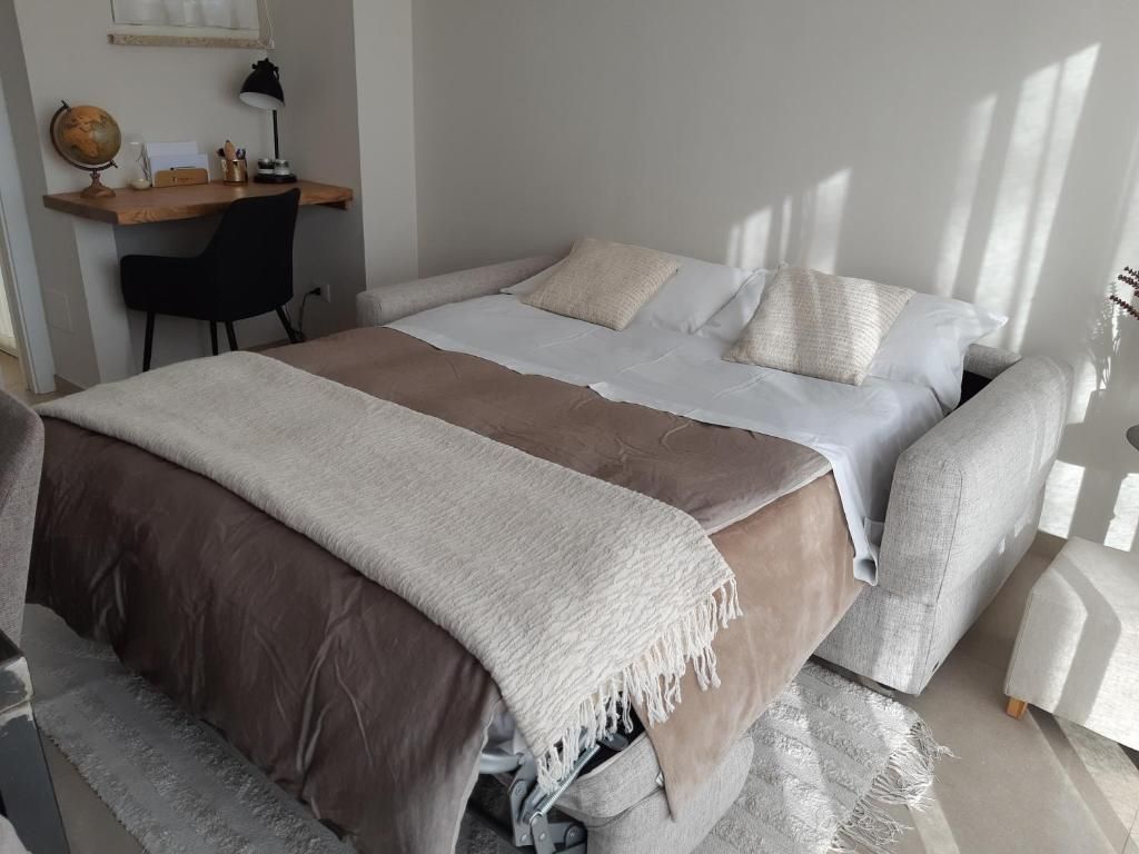 Una camera da letto con un letto, una scrivania e una sedia.