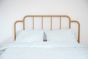 A bed with a metal frame and patterned bedding. - Cute Studio in DT Montreal, 5 mins to bell center (Montreal)