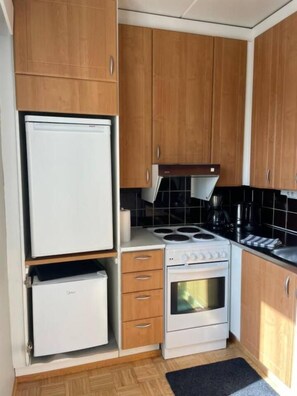 A compact kitchenette with a white refrigerator, a stove, and a small oven. - Everything Walkable: Metro, Shopping Center, Beach (Espoo)
