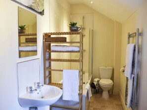 Ein kleines Badezimmer mit Waschbecken, Toilette und Duschbereich.