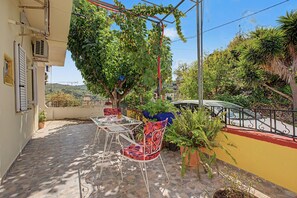 Un patio con mesa y sillas, rodeado de follaje y vistas al paisaje.