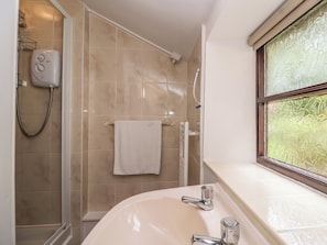 A bathroom with a shower, a sink, and a window. - The Cottage (Bridgwater)