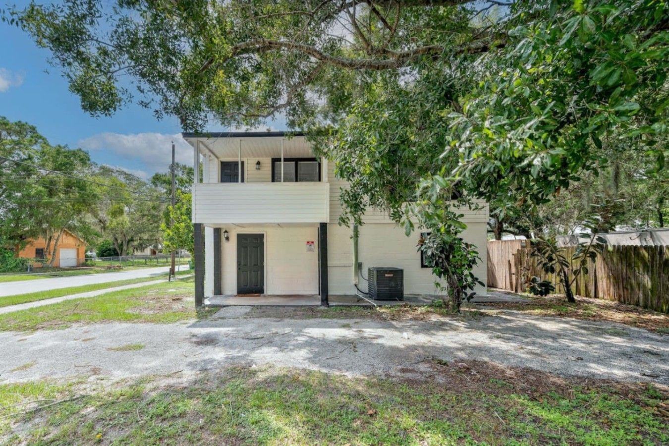 A two-story residential building with a front door, a small porch, and a garage.