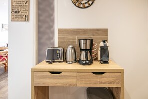 Eine Holz-Küchenarbeitsplatte mit Toaster, Kaffeemaschine und Wasserkocher.
