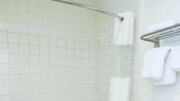A bathroom with a bathtub, a toilet, and a shower curtain.