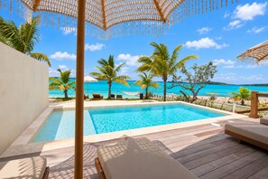 A pool area with lounge chairs, a wooden deck, and a view of the beach and ocean. - Bungalow with pool in georgetown, sleeps 6 people! (Exuma)