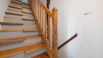 Eine Holztreppe mit Handlauf und einem Schild an der Wand.