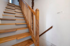 Eine Holztreppe mit Handlauf und einem Schild an der Wand.