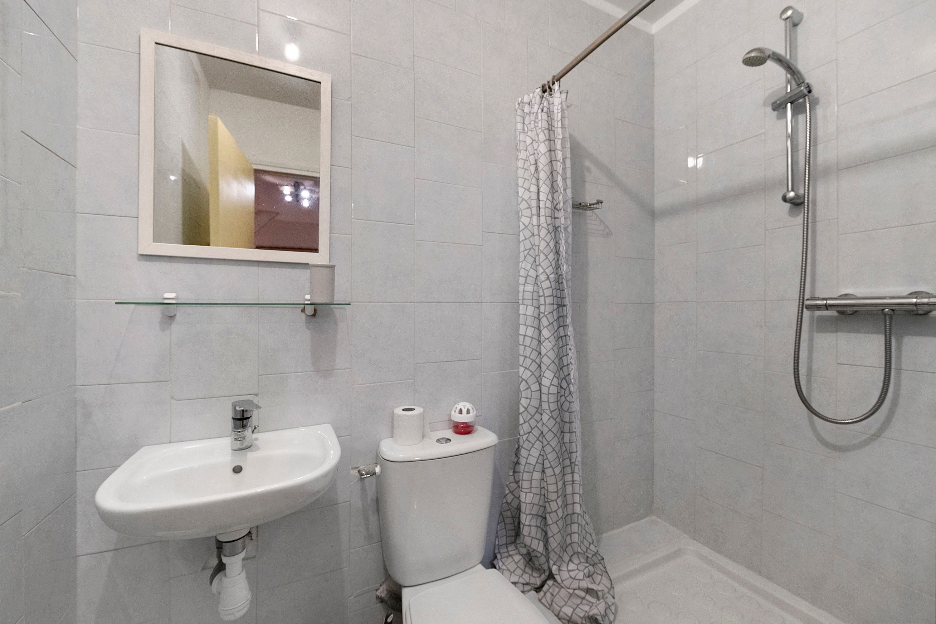 Une salle de bain avec un lavabo, des toilettes et une douche.