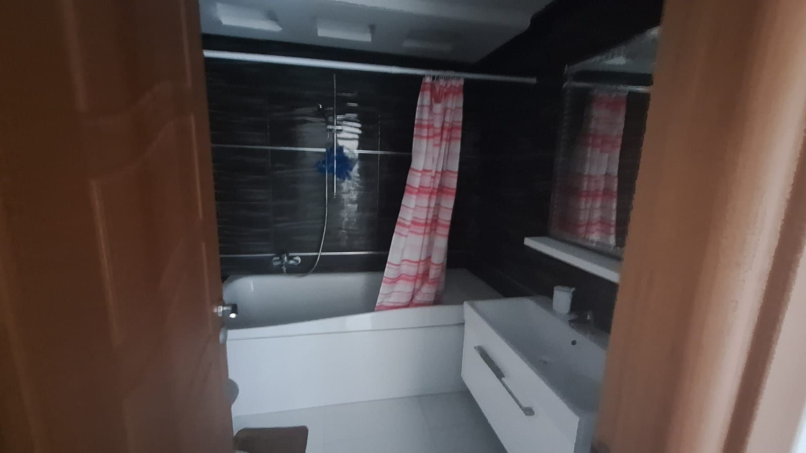Une salle de bain avec une baignoire, un lavabo blanc et un miroir.