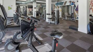 A gym with various exercise equipment, including stationary bikes and weight machines.