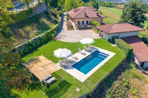 Ein Wohnhaus mit Swimmingpool, Sitzgelegenheit im Freien und einem gepflegten Garten.