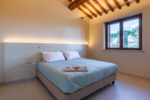 Ein Schlafzimmer mit einem Bett, einem Nachttisch und einem Fenster mit Blick.