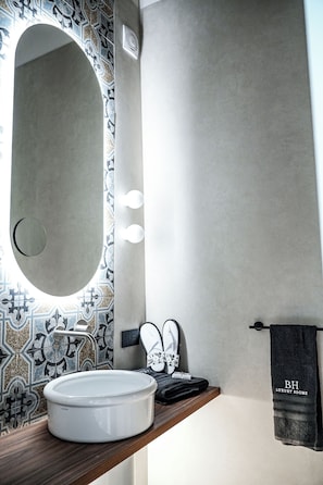 A bathroom with a round sink, a mirror, and a towel rack. - Baggio Hotels - Naples Center (Naples)