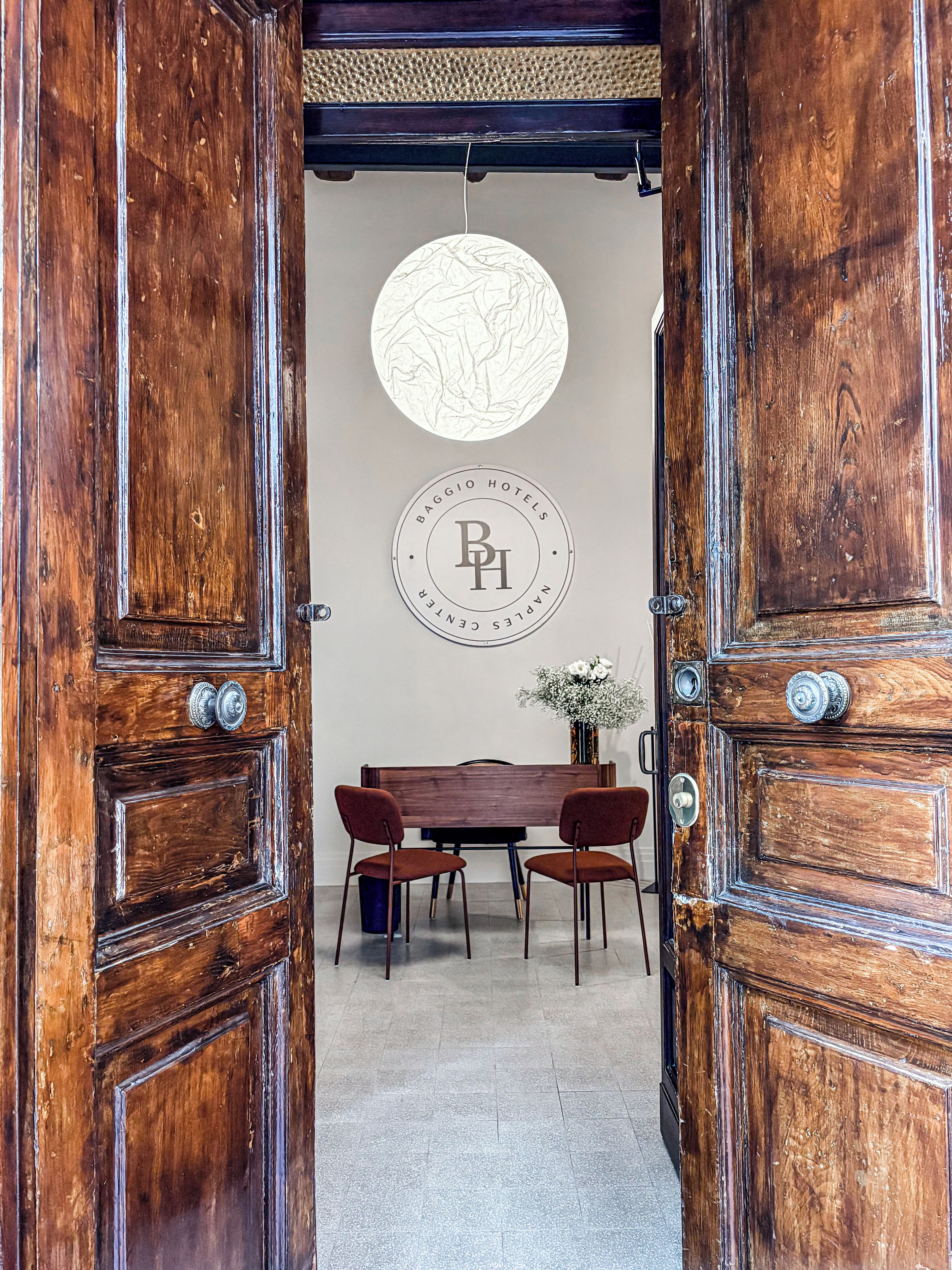 Una porta di legno con uno stemma circolare e un'area pranzo con tavolo e sedie.