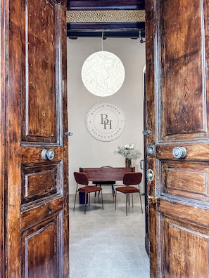 Una puerta de madera con un emblema circular y un comedor con mesa y sillas.
