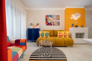 A modern living room with a sofa, colorful armchair, and a glass coffee table. - Pop-Art Apartment I 9 People I 4 BR I Top Downtown (Sofia)