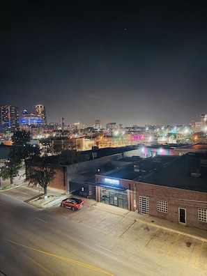 A nighttime cityscape with illuminated buildings and a parking lot. - Deep Ellum Theatre Suite – Private Cinema, Skyline & City Vibes (Dallas)
