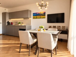 Eine moderne Küche mit grauen Schränken, einem eingebauten Backofen und einer Kaffeemaschine.