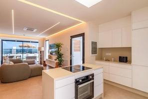 A modern kitchen with a built-in oven and a dining area with a view. - Villa Fragata by Villa Plus (Corralejo)